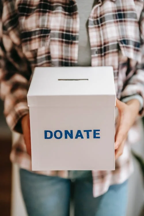 anonymous person showing donation box