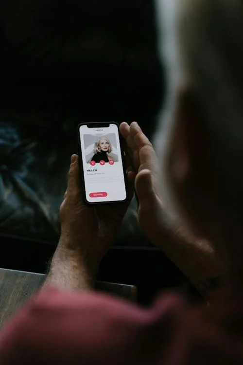 Hands Holding a Smartphone with Dating-Matching App on Screen