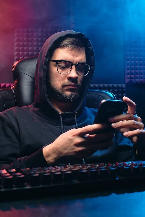 Man in Black Hoodie Sweater Using His Mobile Phone